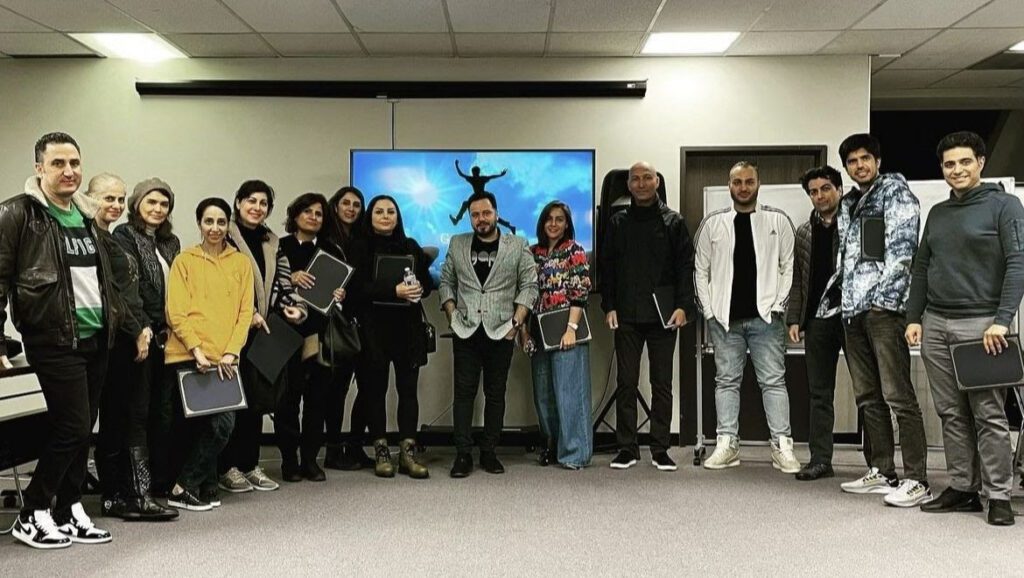 A group of people standing in front of a projector screen.