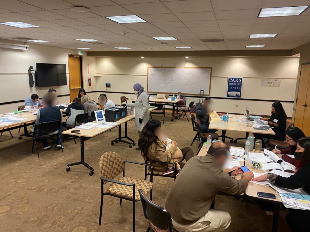 A group of people sitting at tables in an office.