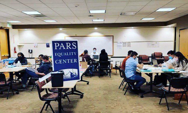 A group of people sitting at tables in an office.